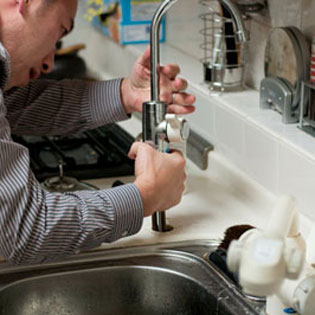 plombier réparant un robinet
