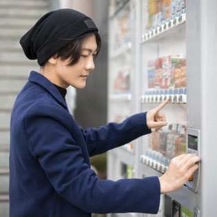 homme utilisant un distributeur automatique