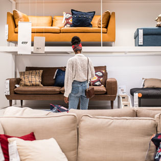 femme recherchant un canapé dans un magasin de meubles