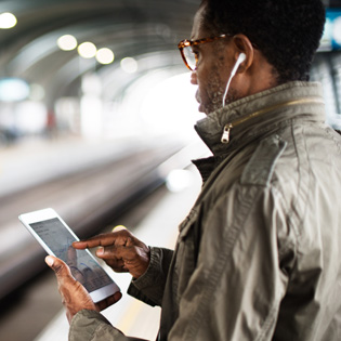 homme sur un quai de train avec une tablette