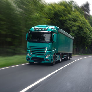 camion vert sur une route de forêt