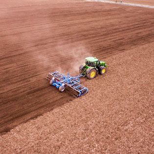 tracteur labourant au milieu d'un champ