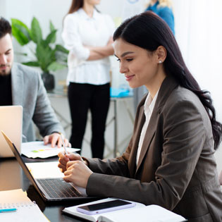 femme souriante devant son poste de travail