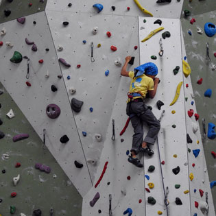 enfant sur un mur d'escalade en intérieur