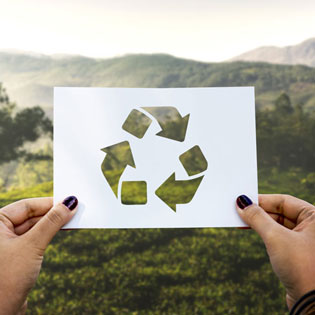 mains tenant un papier avec le symbole du recyclage