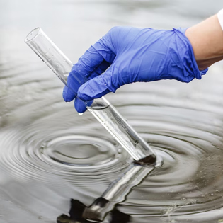 personne gantée récupérant un échantillon d'eau