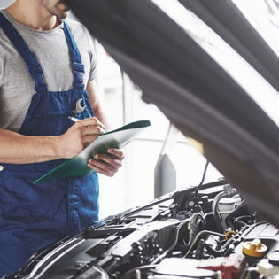 technicien en train d'effectuer un contrôle technique sur une voiture