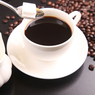 tasse à café avec une cuillère contenant du sucre