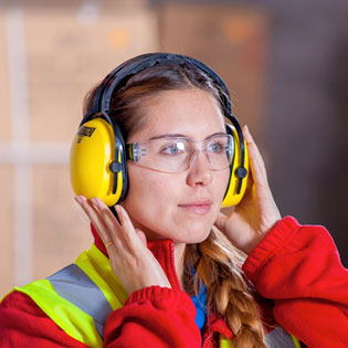 femme portant un casque et des lunettes de protection