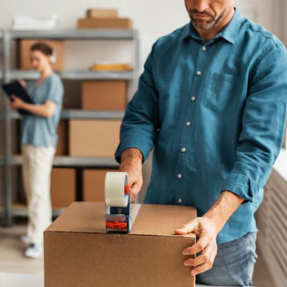 man taping a cardboard