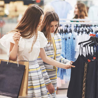 two young women looking at clothes in a store