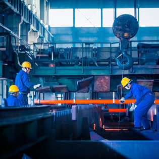 worker shaping a burning metal pipe