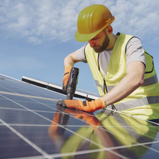 ouvrier posant des panneaux photovoltaïque sur un toit