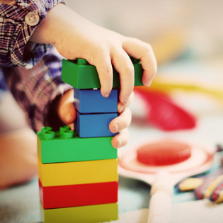 main d'un enfant jouant avec des cubes