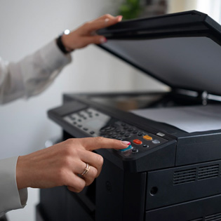 collaboratrice appuyant sur le bouton d''une imprimante pour lancer une numérisation