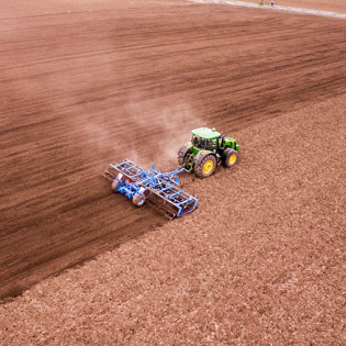 tracteur labourant au milieu d''un champ