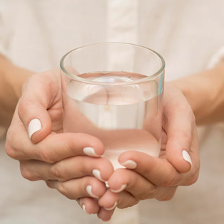 verre d''eau tenu entre deux mains
