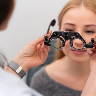 ophtalmologiste positionnant des lunettes pour vérifier la vue d'une patiente