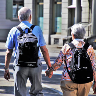 deux personnes âgées marchant main dans la main