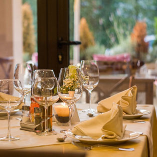 table de restaurant dressée avec des couverts et verres  à pied