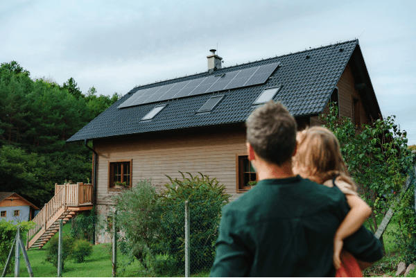 Maison équipée de panneaux solaires observée par une famille - illustration du secteur de l'assurance