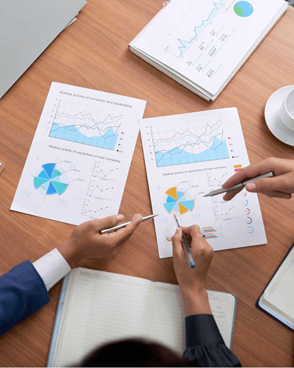 Professionals analyzing economic and financial indicators through graphical reports