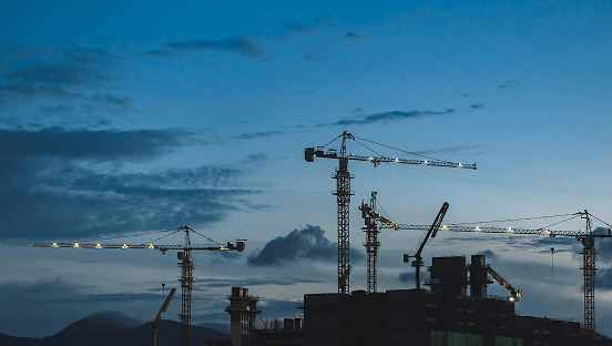Grues et bâtiments en chantier au crépuscule - illustration du secteur de la construction