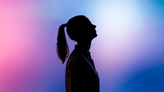 Silhouette d'une personne devant un fond lumineux coloré - illustration du secteur technologie et digital