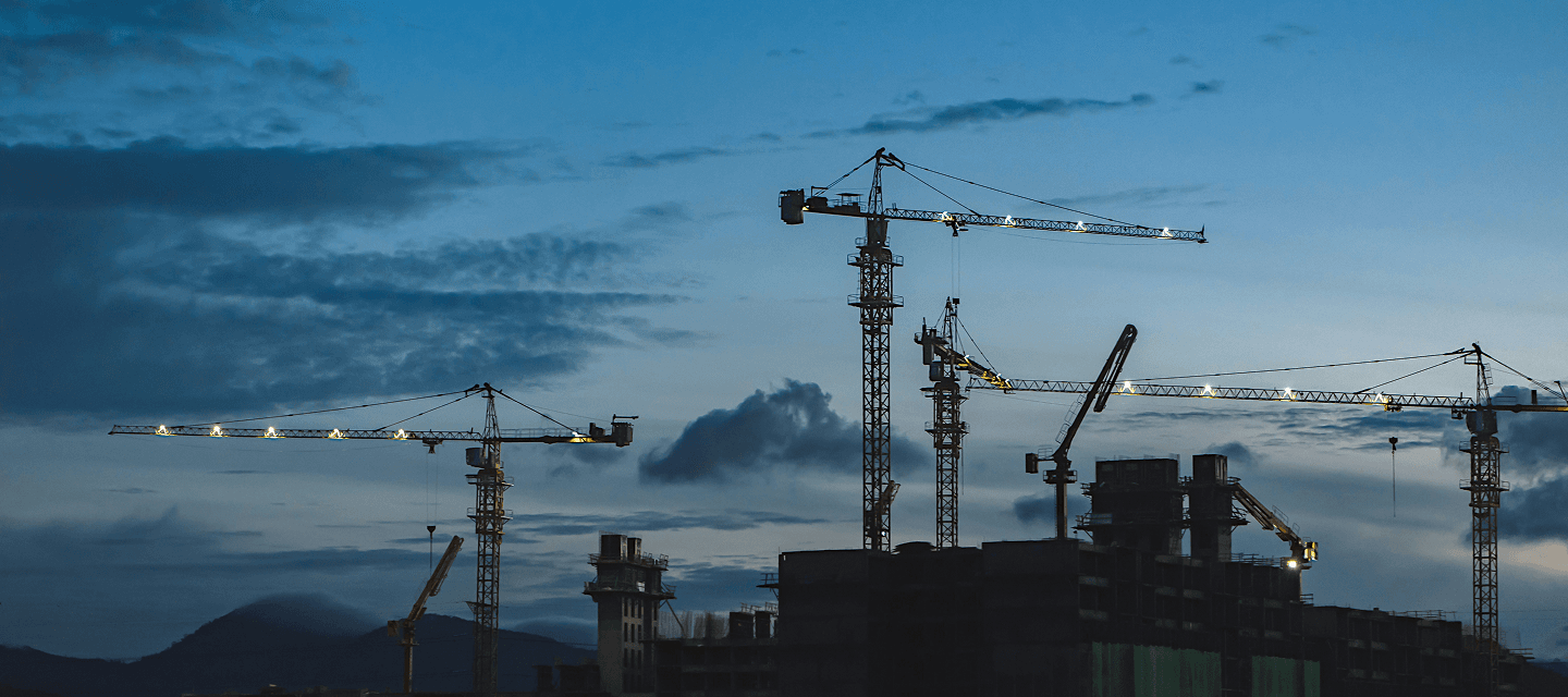 Cranes and buildings under construction at dusk - illustrating the construction sector