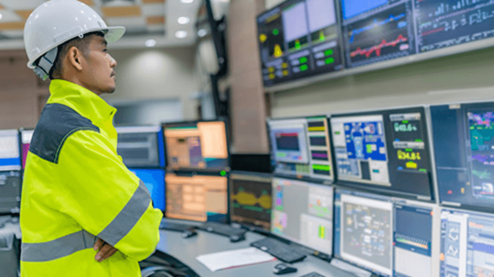 Technicien supervisant un poste de contrôle industriel géré par IA