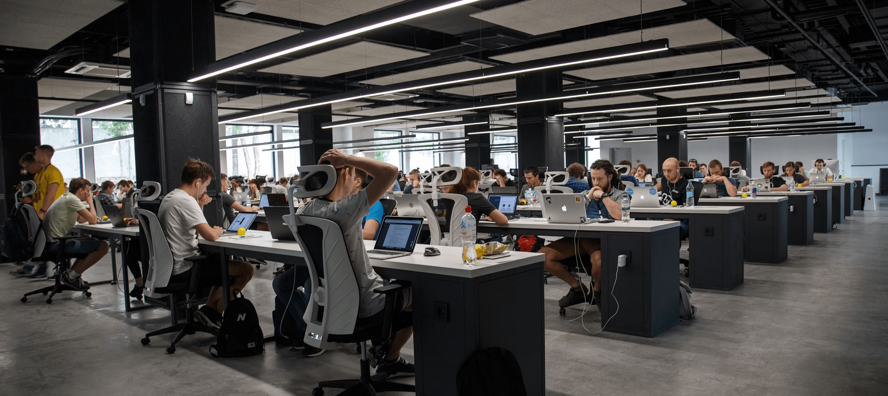 An open-plan office with employees at computer workstations - illustrating the business services sector