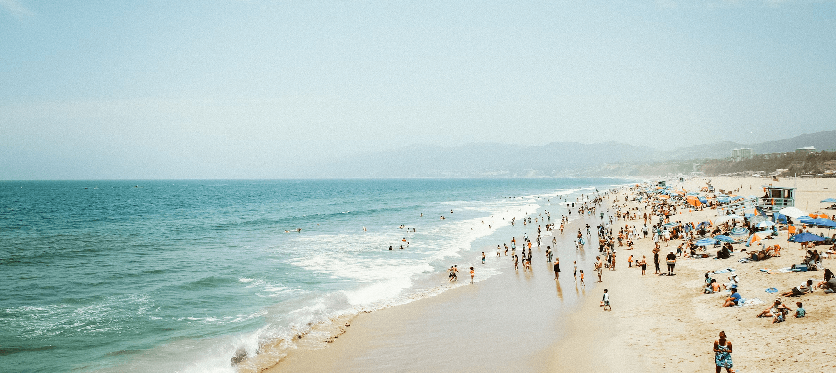 A lively beach scene with holidaymakers - illustrating the tourism, sports, and leisure sector