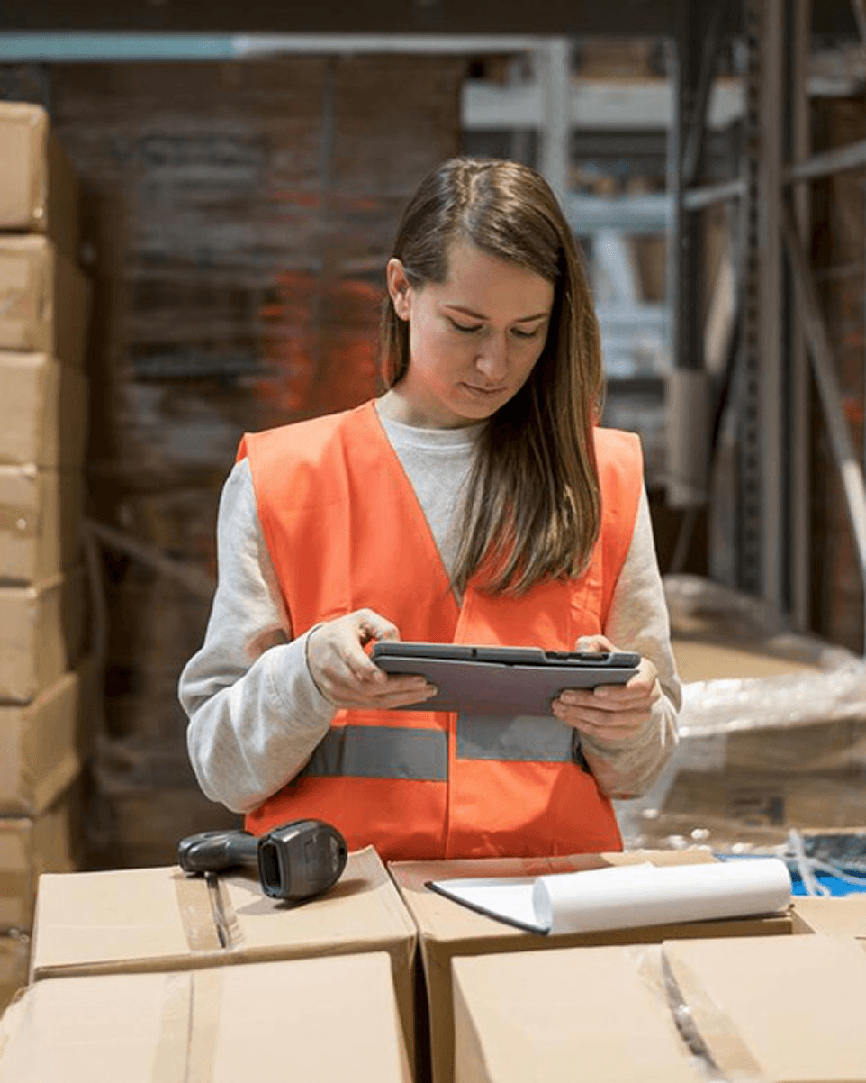 Opératrice gérant des stocks sur une tablette en entrepôt logistique